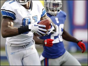 Lions receiver Calvin Johnson eludes Giants safety Antrel Rolle, scoring a Detroit TD in the fourth quarter Sunday.