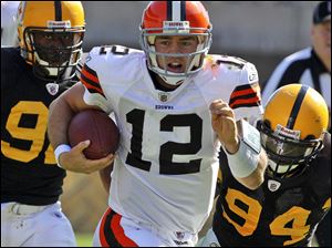 The Browns' Colt McCoy gains yardage after being flushed out of the pocket by the Steelers. 
McCoy was sacked five times and was intercepted twice, but he showed a lot of poise in the loss. Ben Roethlisberger, who returned after a four-game suspension, gets rid of the ball before being pulled to the ground.