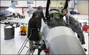 Slug: CTY fighterwing19p Date: 10192010  The Blade/Andy Morrison   Location: Toledo Caption: Master Sgt. Jeff Cobb of the 180th Fighter Wing of the Air National Guard, shows  the interior of an F-16 to Toledo City Council members Adam Martinez and Steven Steel during a tour of the base, Tuesday, 10192010.