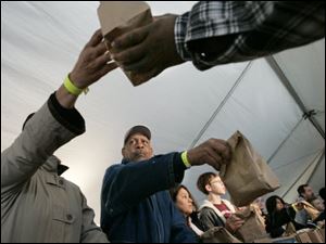 Volunteers including Yolanda Woodberry, left, and her husband Warren Woodberry, second from left, distribute free bag lunches during the 2009 1Matter Tent City.