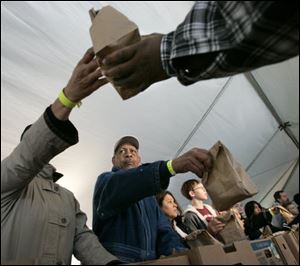 Volunteers including Yolanda Woodberry, left, and her husband Warren Woodberry, second from left, distribute free bag lunches during the 2009 1Matter Tent City.