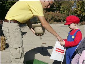 CTY littleboo22p  ZooTeen [hence, volunteer] Evan Clasey (cq), 17, of Perrysburg, gives Ethan Pooley (cq), 4, of Bowling Green, a candy at one of the trick-or-treat stations set up for Little Boos. Little Boo at the Zoo taking place again this year at the Toledo Zoo on October 21, 2010, and continuing on Friday, the 22nd. Pumpkin Path, for solder children, is Saturday and Sunday. Both events are family-friendly trick-or-treat activities. Jetta Fraser/The Blade