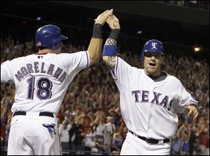 Mitch Moreland and Josh Hamilton celebrate after scoring on a double by Vladimir Guerrero in the fifth inning.