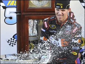 Denny Hamlin celebrates his victory by spraying the crowd with champagne. He has won three straight at Martinsville.