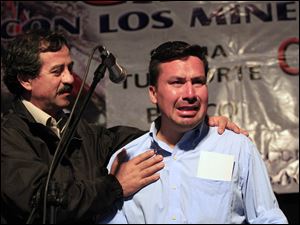 Edison Pena, right, gets support from Juan Illanes during a ceremony for the miners. The men are beginning to speak about the emotional struggles they faced underground, and now, above.