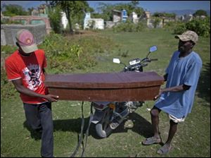 Two men carry the coffin of Frist Fleurant, 10, who died of cholera, before his burial in Rossignol, Haiti.