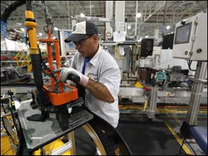 John Backers assembles a six speed transmission Monday at the Ford Motor Co. Van Dyke Transmission Plant in Sterling Heights, Mich.