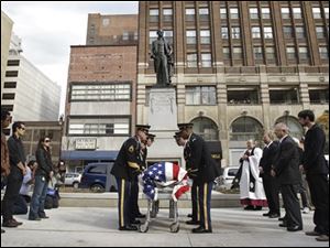 The remains of Stevens T. Mason, Michigan's first governor are carried by an honor guard during a re-interment ceremony in Detroit Capitol Park in Detroit, Wednesday. Mason has been buried once again on the site of the first state capitol. The flag-draped metal casket was placed in a crypt below a bronze statue of the man known as the "Boy Governor."