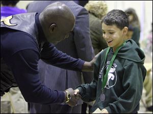 Toledo Mayor Mike Bell, left, congratulates seventh grader Mariam Abou-Dahech on a job well done.