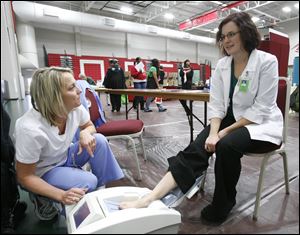 Among those in attendance were Kelly Wirkner, left, an X-ray technician at Bay park Community Hospital, scanning the heel bone density of Owens dietetic student Kerry long.