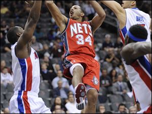 Detroit's Rodney Stuckey, left, and Austin Daye attempt to stop the New Jersey's Devin Harris.
