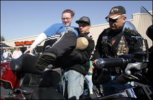 CTY run18p  Julian Wayne helps Bri Mullinger, center, get on the 2007 Harley Davidson Classic of Rick Marinski (cq), of Toledo, right, who will be giving her a ride in the benefit run. Over 230 participate in the event. A memorial ride to honor Cody Brown begins at the Toledo Harley Davidson dealership in Sylvania Township, Ohio on October 17, 2010, with Cody's parents, Jodi and Jeff Brown, his sister Shelby and Cody's best friend Bri Mullinger riding nearby. The ride is ten months and a day after 15-year-old Brown was struck and killed by an Amtrak train as he and Bri crossed the tracks near Springfield High School. The Lucas County Sheriff department's motorcycle unit riders donated their time to escort the ride. Jetta Fraser/The Blade