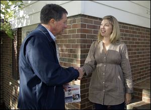 John Kasich greets Nicole Carrier while campaigning in Worthington. ‘Just when we think we've knocked on the last door, we're going to knock on a few more doors,' Mr. Kasich said.