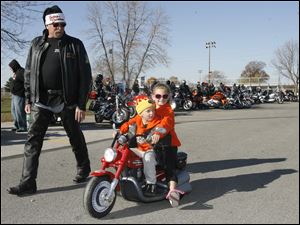 CTY toyrun08p  Grandfather Bill Daniels, of Temperance, Michigan, with his grandchildren Herbie, 4, and Shayla (cq) Haynes (cq), 7, both of Toledo, cruising. Santa Claus, Michael Wenzel (cq), of Toledo, founder and organizer of the 21st Annual Bikers of N.W. Ohio Toy Run, and Toledo Mayor Mike Bell lead about 1500 riders from the Toledo Speedway inToledo to the Lucas County Recreation Center in Maumee, Ohio on a benefit ride for children of Harbor. The ride was escorted by Lucas County Sheriff Department motorcycle officers who donated their time for the benefit. "Thank you to everyone who came out for the kids", says Jean Drees (cq), marketing director for Harbor, noting that Harbor is the largest provider of mental health services for children in northwest Ohio. The current poor economic situation in the area has added to the community's needs, as so many lives have been turned "upside down". Everybody needs help at some point, says Drees. Over the half dozen of so years which Harbor has been the Run's beneficiary, the organization has received net proceeds close to $80,000.  With the cash donations which they received today, Harbor tries to make the most from it by bargaining with local stores. Jetta Fraser/The Blade