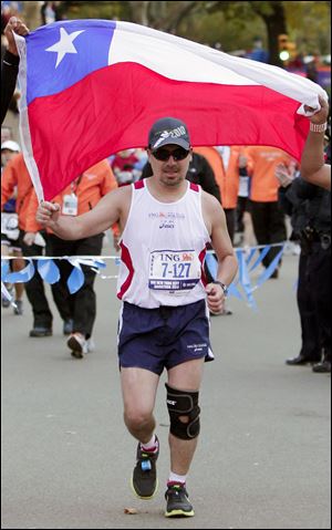 Edison Pena carries a Chilean flag as he finishes the New York City marathon. The rescued miner finished in 5 hours, 40 minutes, and 51 seconds.