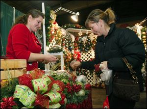 CTY craftshow08p  Tiffaney (cq) Shaver, of Fostoria, left, sells one of her homemade wreaths to Cori (cq) Lindsay (cq), of Toledo, at the craft show. The Holiday Craft and Gift Marketplace, the annual craft show that is being held for the 15th year at the Lucas County Recreation Center in Maumee, Ohio on November 7, 2010. 