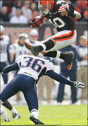 Browns running back Peyton Hillis leaps over Patriots safety Josh Barrett. Hillis ran for 184 yards and two touchdowns.