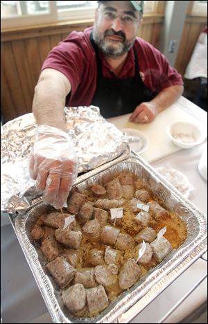 Frank Mikhail, a House of Meats worker, inserts judging markers into kielbasa samples at the Polish-American Community of Toledo's kielbasa cook-off. 