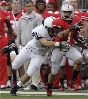 Ohio State's Dan Herron tries to pull away from Penn State's Chris Colosanti. Herron finished with 190 yards rushing on 21 carries.