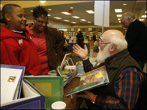 Toledoans Parker Chatman, 9, and his mother, Terri Parker Chatman, talk with children's author Jeffery Schatzer at the Writers on the River book fair in Temperance.