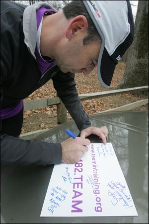 Scott Sandvik writes a greeting to support Ernie Lewis during his 52-mile run at Oak Openings Preserve Metropark that he dubbed the Double 0/Double Marathon to raise funds for blood cancer.