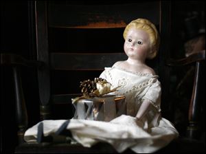 SLUG: CTY toys24p                    11/18/2010 The Blade/Amy E. Voigt               Maumee, Ohio  CAPTION:  A doll on display from the 1840's, that is wearing the original dress, on a chair near one of the decorated trees on opening day for the Joys and Toys of Christmas Past at the Wolcott House Museum on November 18, 2010.