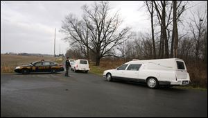 Three hearses arrive at a sheriff's checkpoint to take away bodies found in a Knox County wildlife preserve.