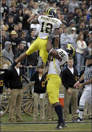 Tight end Kevin Koger lifts up teammate Roy Roundtree after the Wolverines scored a touchdown against Purdue.