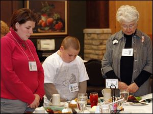 At this season's local gathering of Mayflower descendants and their spouses, Ashley and Blake Kaylor, left, of Woodville and June Chapin, right, of Fremont bow their heads in prayer at the table.