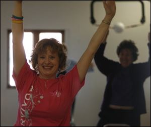 Susan Papenfuss of Maumee, who has battled breast and ovarian cancer with standard treatments, participates in a yoga class. She started doing chair yoga last year while receiving chemotherapy.