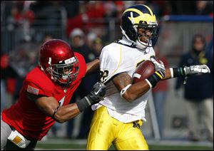 Michigan's Darryl Stonum tries to shake Ohio State's Devon Torrence. Stonum led Michigan with seven catches for 81 yards.