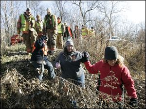 CTY missing29p 11/28/10  The Blade/Dave Zapotosky A group of searchers descend a hill on Ranger Highway in Morenci, Michigan, so they can begin a search for the missing Skelton children, in a wooded area along Lime Creek, Sunday, November 28, 2010.  Summary:  Search for missing Skelton children in Morenci, Michigan.
