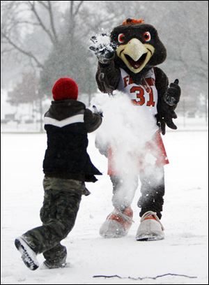 Frieda the Falcon, one of Bowling Green State University's mascots, squares off with Logan McGuire, 9, of Perrysburg in a snowball fight outside of Anderson Arena. 
