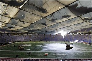 Snow breaks through the roof of the Metrodome in Minneapolis. No one at the stadium was hurt Sunday, but the Vikings' Monday night game against the New York Giants will be moved to Ford Field in Detroit. 