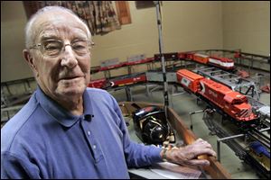 Bob Sawyer shows off his model train set at his South Toledo home. He says his father went to Sears on Christmas Eve in 1931 to buy him his first train set, pieces of which are still in the Sawyer family.