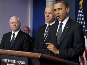 President Barack Obama, accompanied by Vice President Joe Biden, center, and Defense Secretary Robert Gates, speaks Thrusday about the Afghanistan-Pakistan Annual Review at the White House.