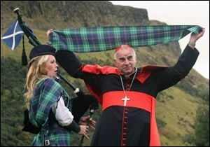 Cardinal Keith O'Brien unveils the first Papal visit plaid. 