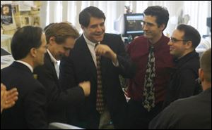 Blade publisher John Robinson Block, left, celebrates with reporters Mitch Weiss, Michael Sallah, and Joe Mahr and photographer Andy Morrison, right, after The Blade learned it had won the Pulitzer Prize for investigative reporting for its 'Buries Secrets, brutal Truths' series on the Vietnam War.