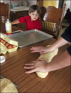 Kevin Yoder, 4, watches as his mother rolls out Knoerle German bread dough.