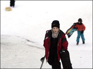 ROV sledding29p  The Blade/Lori King  12/29/2010  Maumee resident Conor Dean, 11, center, makes is way up the new sledding hill at Side Cut Metropark in Maumee, Ohio.