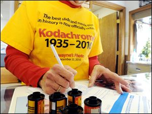 Val Addis signs in several rolls of Kodachrome slide film at Dwayne's Photo in Kansas City. Kodak had provided the shop with enough chemicals to process the film through the end of 2010. Printed on Ms. Addis' shirt is an epitaph for the film; she and other employees gathered in front of the late this week for a photo on the last frame on the last roll of the film.
