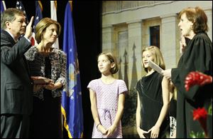 Gov. John Kasich, with his wife, Karen, takes the ceremonial oath of office from Chief Justice Maureen O'Connor. With the couple are their twin 10-year-old daughters, Reese and Emma.