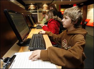 Slug: NBRN exhibit12p  Date:   01052011       The Blade/Andy Morrison       Location:  Monroe      Caption: Trey Eberline, 11, uses a computer as he and other fifth graders from Arborwoods South Elementary visit mobile Library of Congress 
