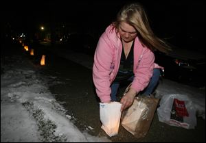 Slug: NBRN lights12p  Date:   01062011       The Blade/Andy Morrison       Location:  Monroe      Caption:   Vickie Bensley lights a luminary near her home at the corner of E. Second Street and S. McComb as part of the celebration of the 12th night of Christmas and the Epiphany, Thursday, 01062011. Summary: