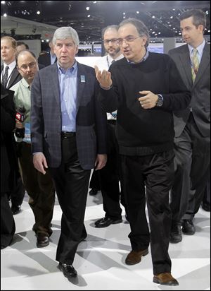 Sergio Marchionne, right, talks with Michigan Gov. Rick Snyder during the media preview of the auto show. Mr. Marcionne said improvements are in the works for the Toledo-made Jeep Liberty.