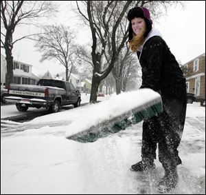 Tayler Meinen, 13, shovels snow from a sidewalk on Thoman Place in West Toledo.