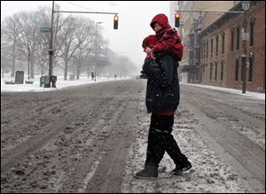 Payton Spain, 3, gets a ride on the shoulders of his dad, Steven, as they head to a bus station in downtown Toledo.