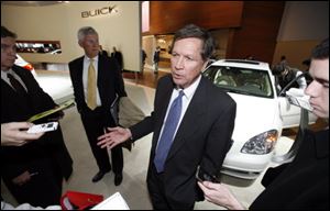 Gov. Kasich speaks to reporters while touring the North American International Auto Show in Detroit.