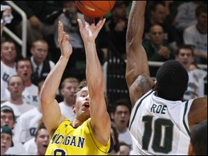 UM's Zack Novak shoots a 3-pointer over MSU's Delvon Roe.