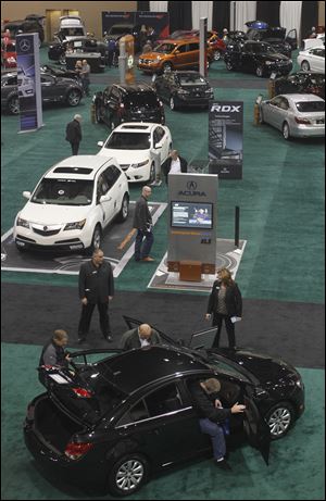 The 200 cars, trucks, and motorcycles, including the Chevy Cruze at the bottom of the photo, draw visitors to the opening of the Greater Toledo Auto Show. The annual extravaganza at the SeaGate Convention Centre opened Thursday, and will run through Sunday. The show is sponsored by area dealers.
